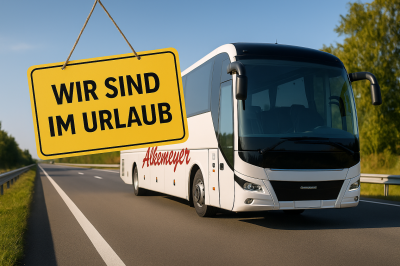 Weißer Reisebus mit „Alkemeyer“-Schriftzug auf Landstraße, daneben ein Schild mit der Aufschrift „Wir sind im Urlaub“ – Sommerpause beim Reisedienst